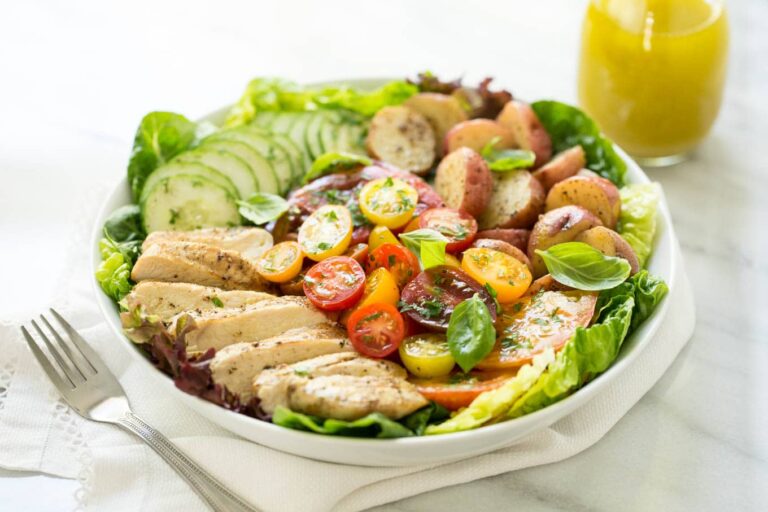 Description: Sliced grilled chicken breast served over a bed of mixed greens with cherry tomatoes and cucumbers.